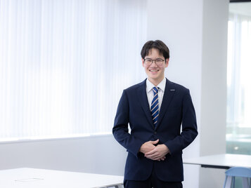 オフィスに立つモビリティ第２営業部K.Sさん　