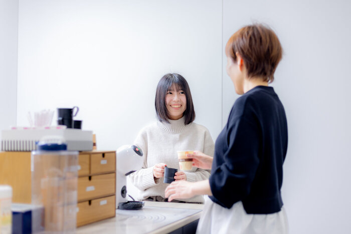 カフェコーナーで職場先輩と談笑する業務部U.Sさん
